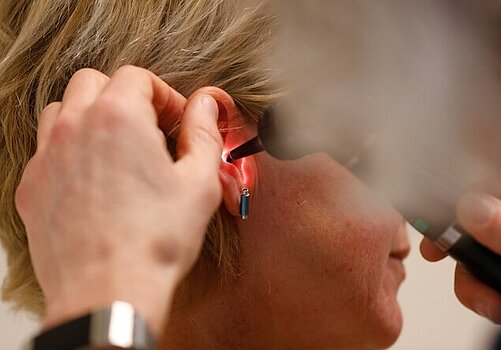 Arts onderzoekt oor van patiënt (foto ANP)