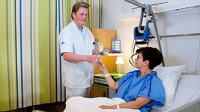 Verpleegkundige geeft patiënt medicatie op operatie opname afdeling | CWZ Nijmegen