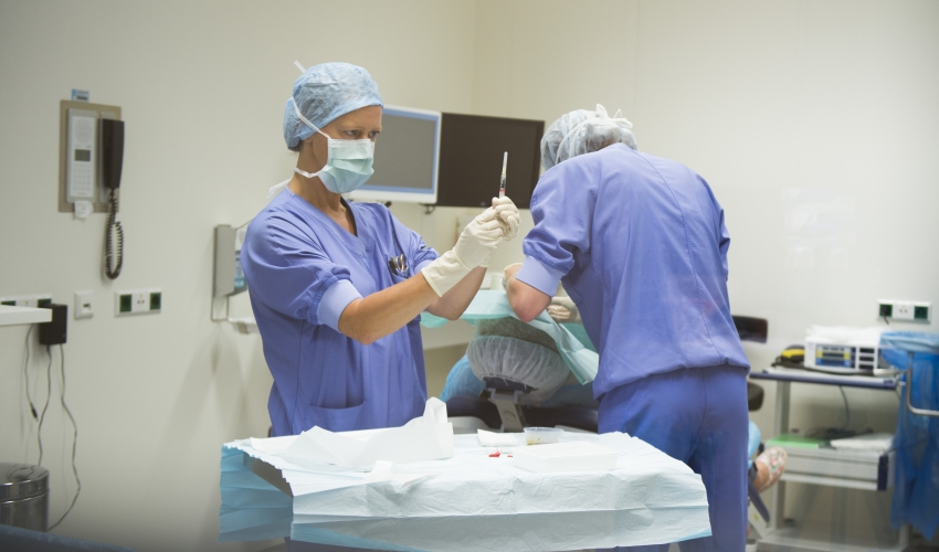 De OK-assistent (links) bereidt de injectie in de oogkliniek CWZ Nijmegen. Oogarts Suze Valen (rechts) buigt zich over Angelique Horruitiner om de steriele doek neer te leggen 